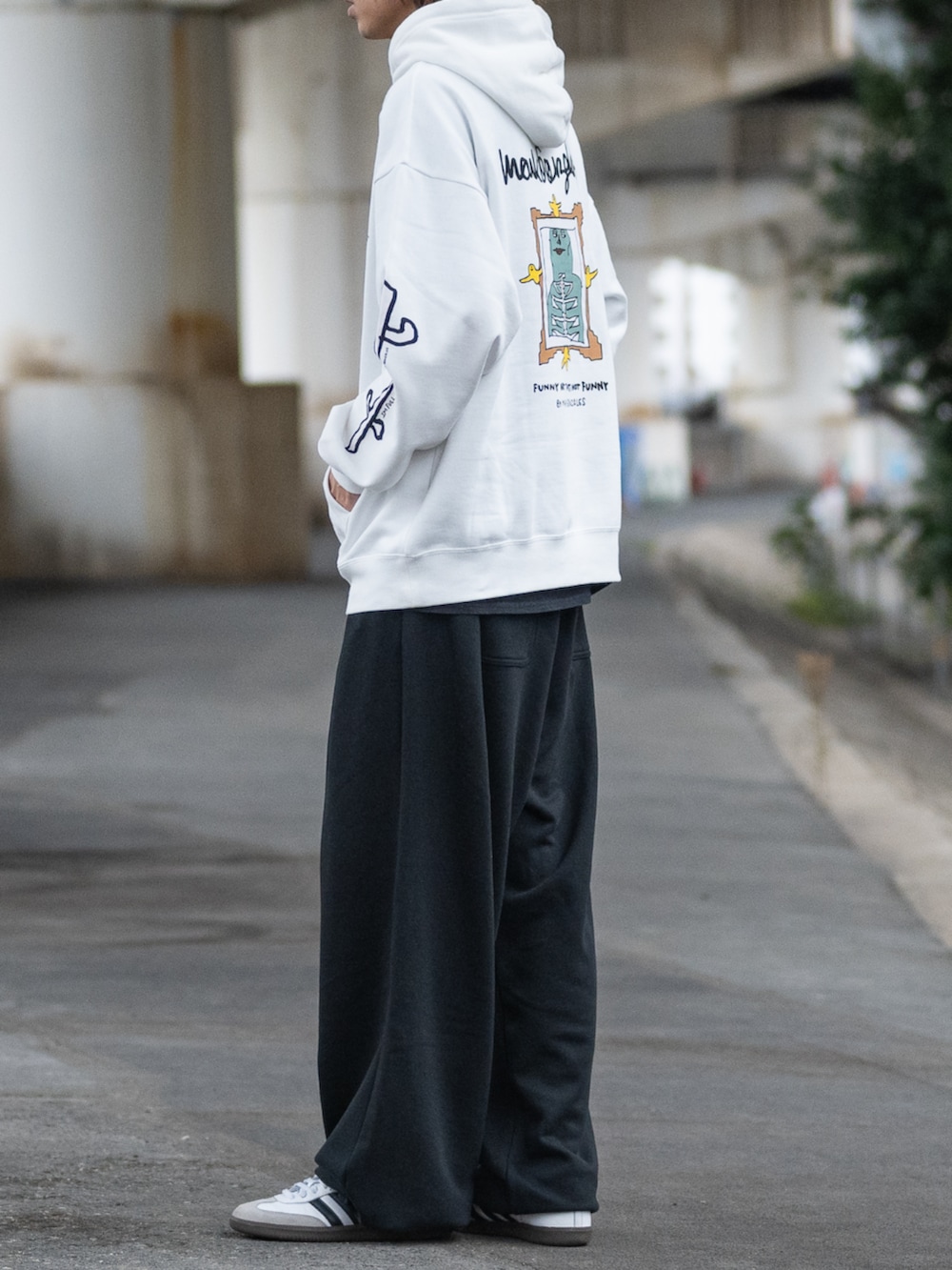 ホワイト系のスニーカー、ブラック系のスウェットパンツ、グレー系のパーカーを着用したメンズの冬コーディネートの2枚目の写真