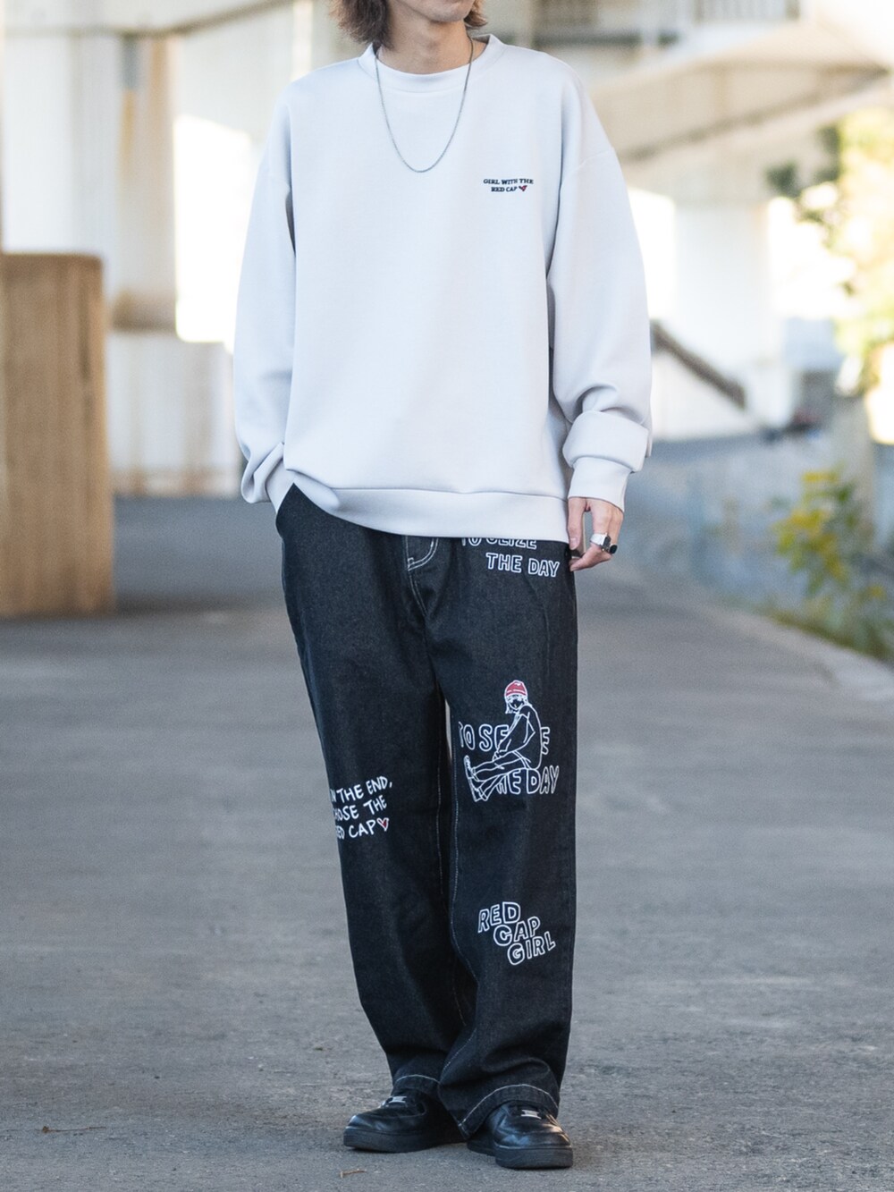 グレー系のスウェット、ブラック系のデニムパンツを着用したメンズの冬コーディネートの3枚目の写真