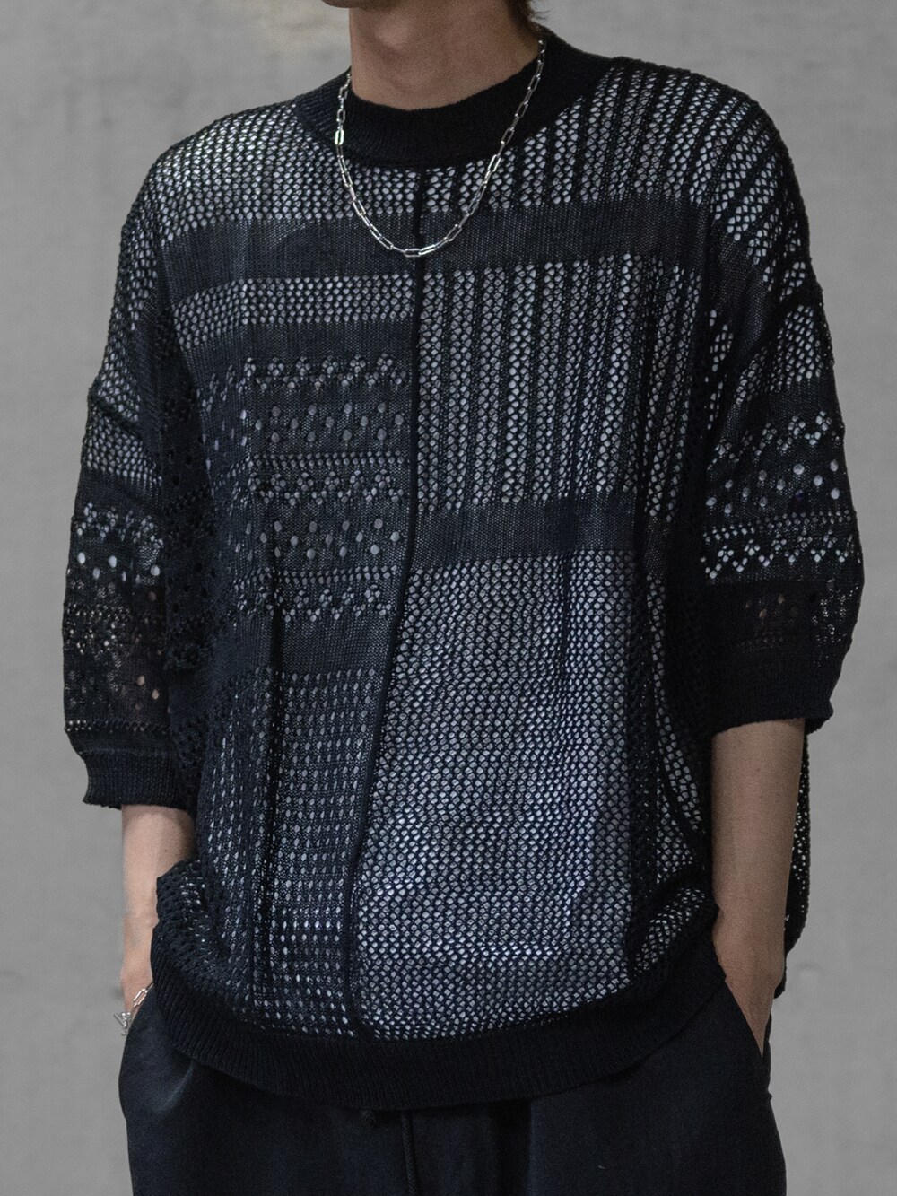 グレー系のスラックス、ブラック系のドレスシューズ、ブラック系のニット/セーターを着用したメンズの春コーディネートの2枚目の写真