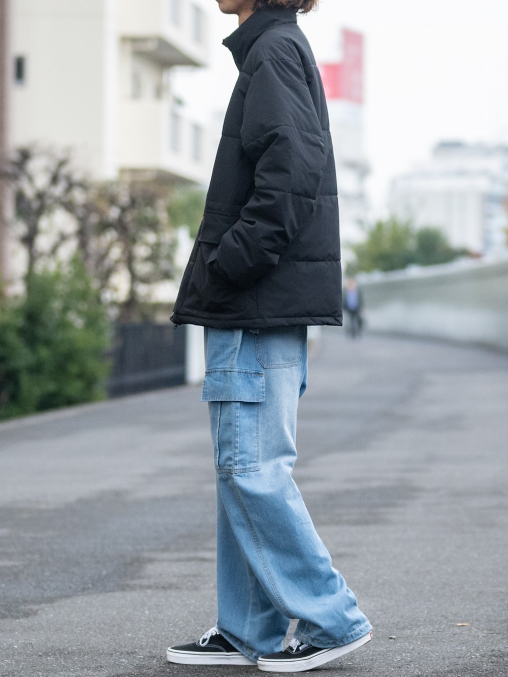 ブルー系のデニムパンツ、ブラック系のダウンジャケット/コートを着用したメンズの冬コーディネートの2枚目の写真
