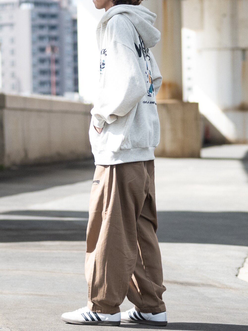 ベージュ系のデニムパンツ、グレー系のパーカーを着用したメンズの秋コーディネートの2枚目の写真
