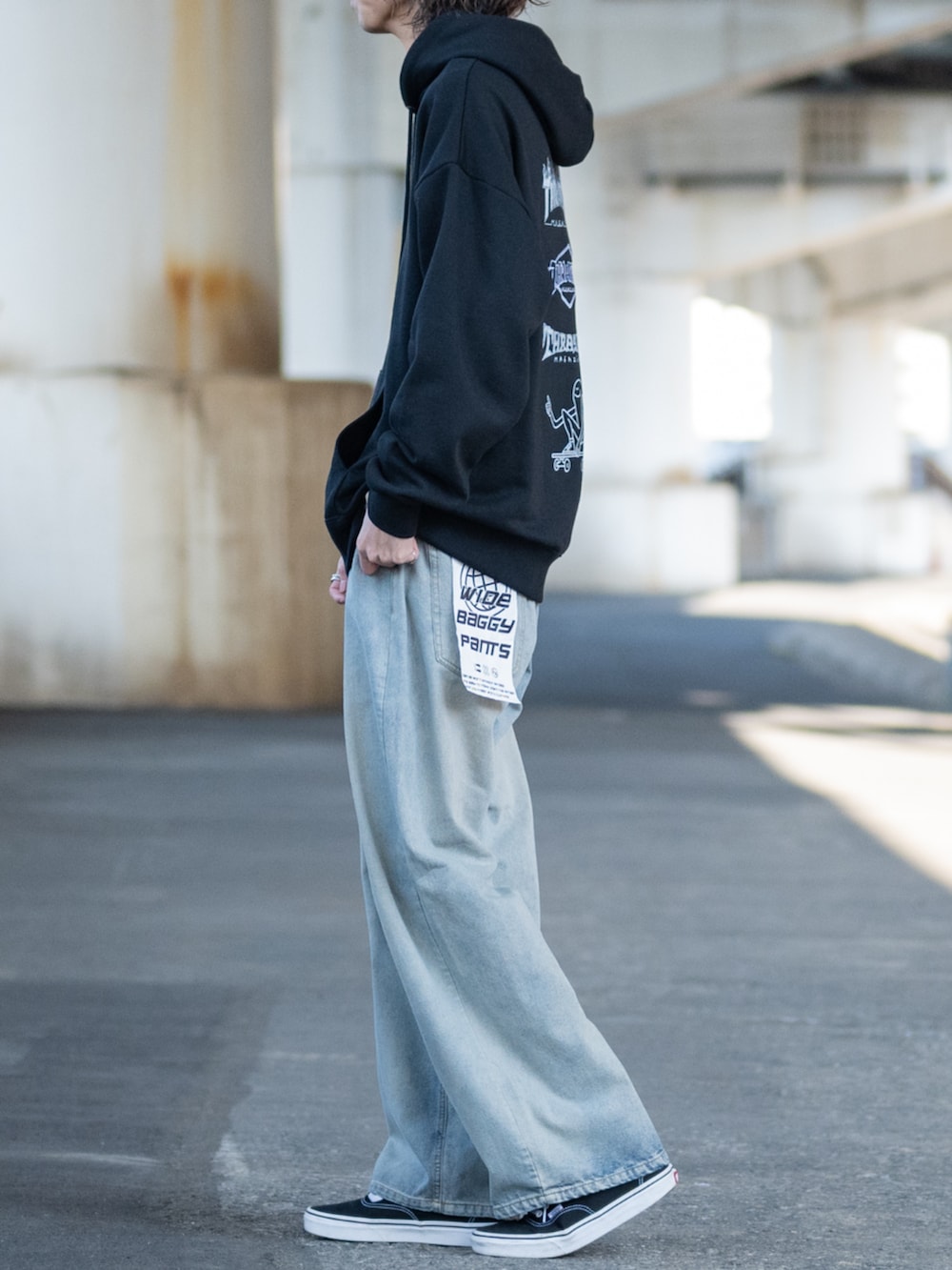 ブラック系のスニーカー、ブルー系のデニムパンツ、ブラック系のパーカーを着用したメンズの冬コーディネートの2枚目の写真