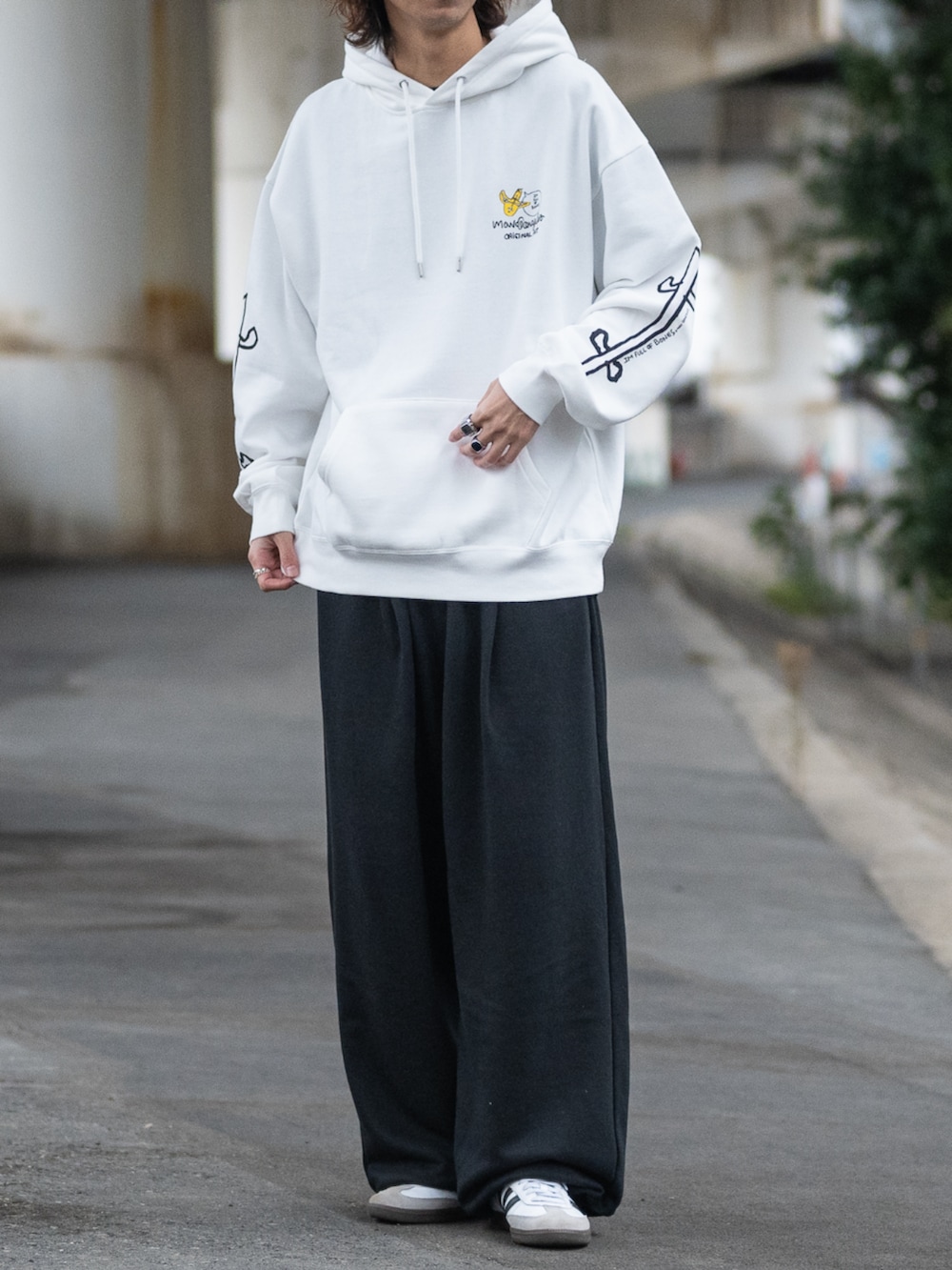 ホワイト系のスニーカー、ブラック系のスウェットパンツ、グレー系のパーカーを着用したメンズの冬コーディネートの3枚目の写真