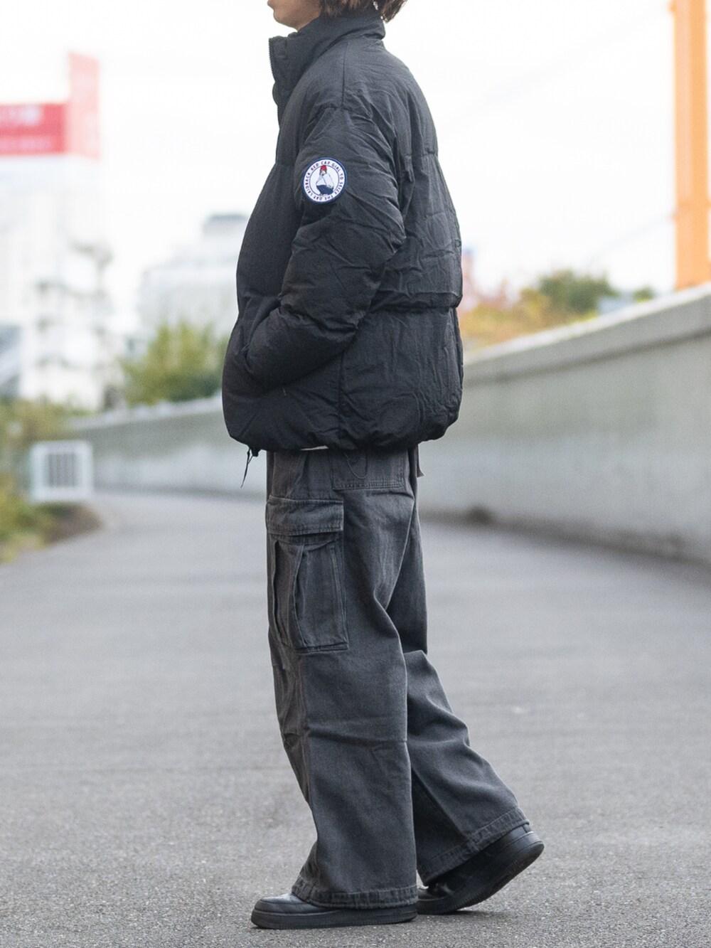 ブラック系のデニムパンツ、ブラック系のダウンジャケット/コートを着用したメンズの冬コーディネートの2枚目の写真