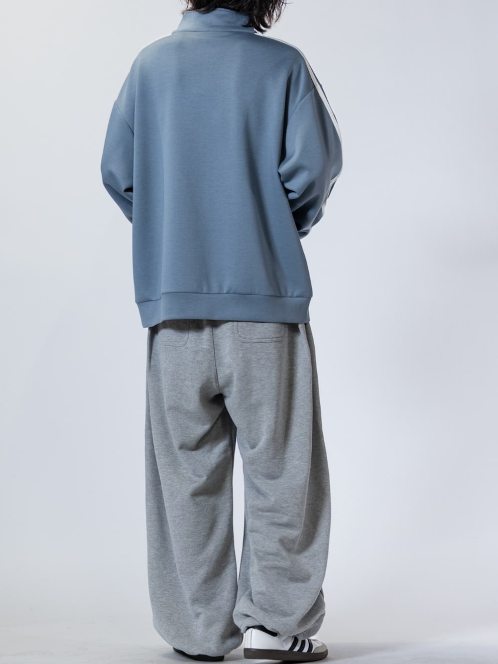 ホワイト系のスニーカー、グレー系のスウェットパンツ、ブルー系のスウェットを着用したメンズの春コーディネートの3枚目の写真
