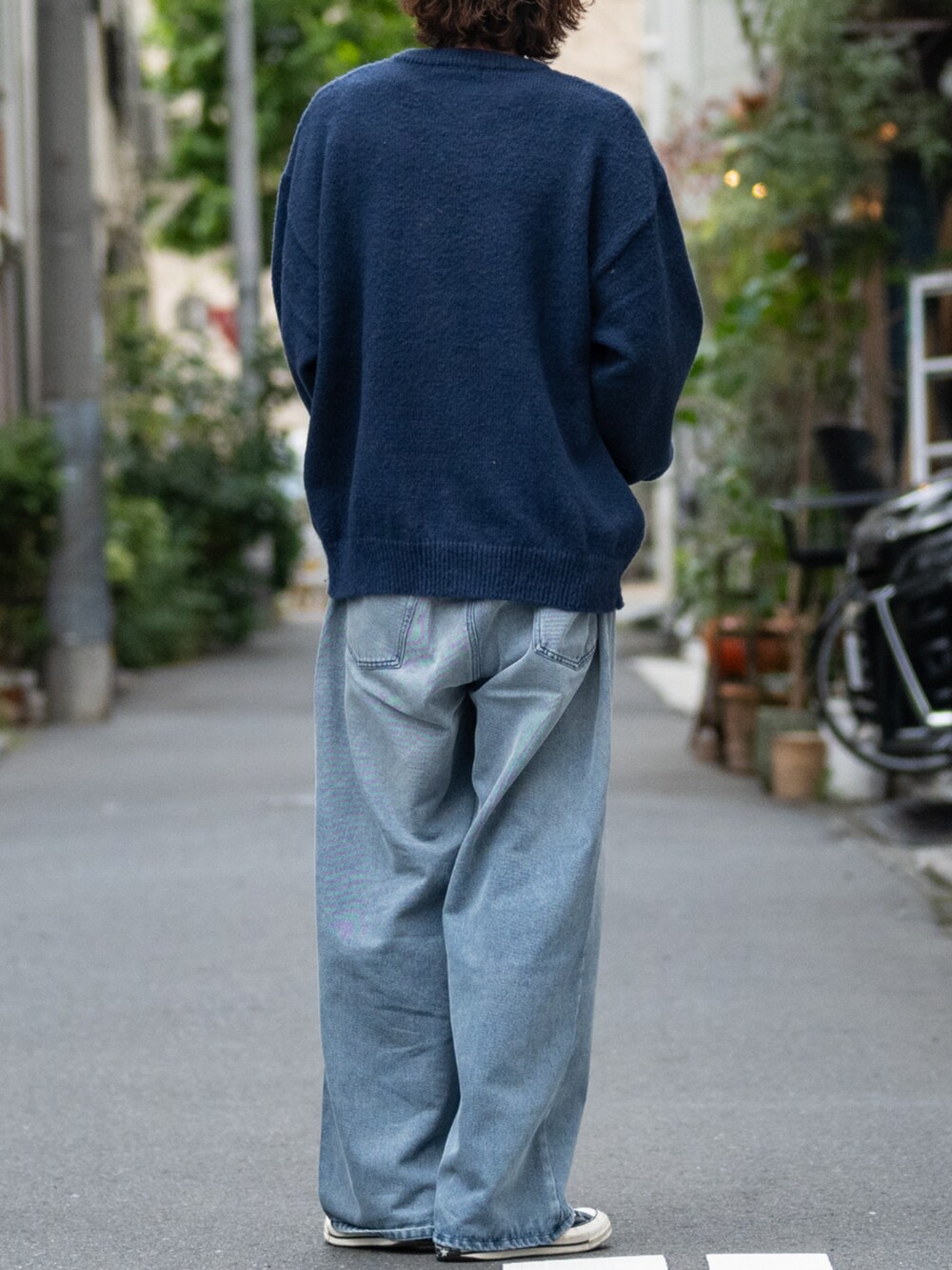 ブラック系のスニーカー、ブルー系のデニムパンツ、ブルー系のニット/セーターを着用したメンズの冬コーディネートの3枚目の写真