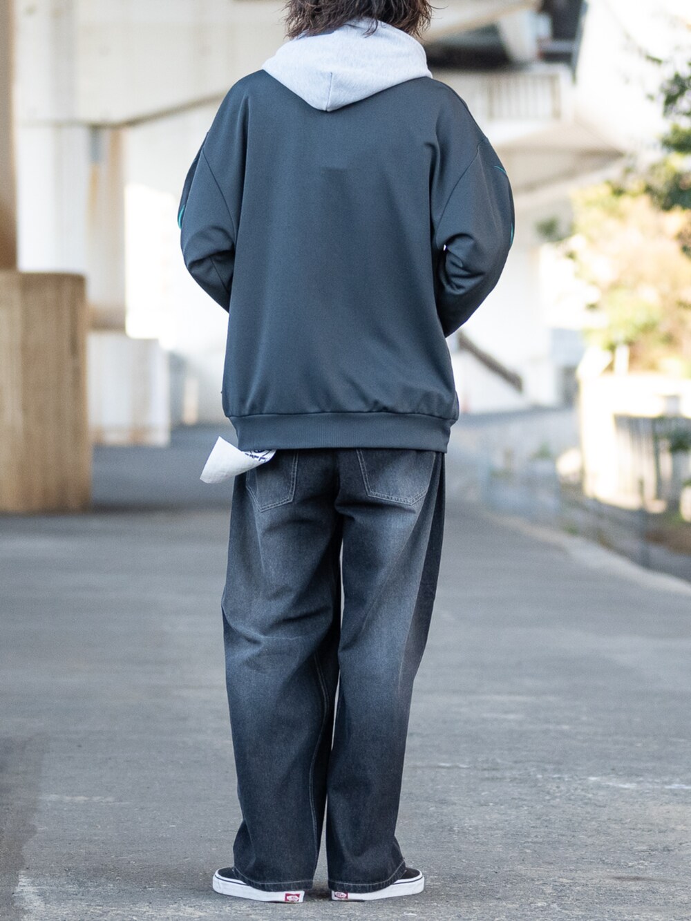 ブラック系のスニーカー、グレー系のパーカー、ブラック系のデニムパンツを着用したメンズの冬コーディネートの3枚目の写真