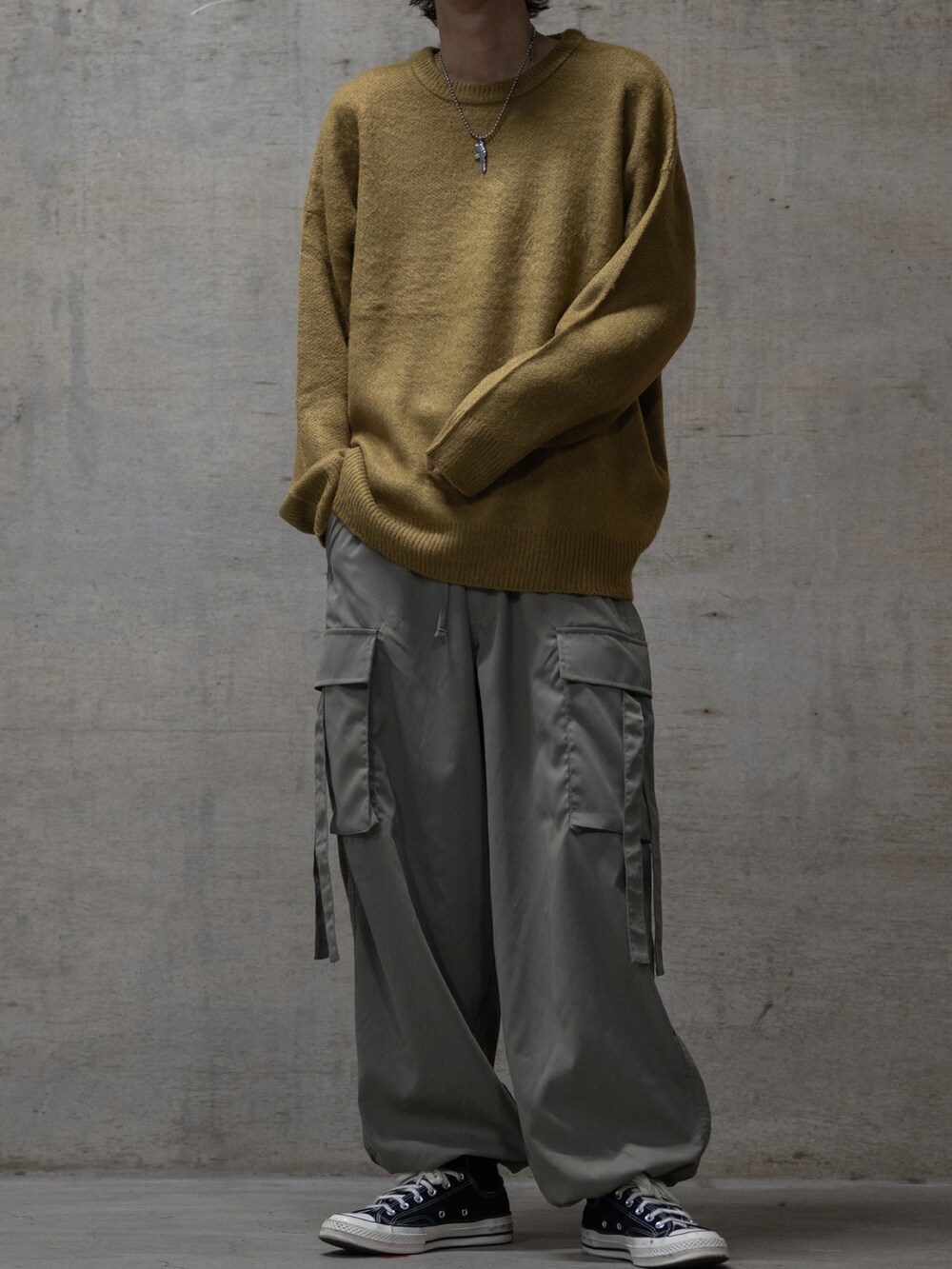 グリーン系のカーゴパンツ、ブラック系のスニーカー、イエロー系のニット/セーターを着用したメンズの秋コーディネートの2枚目の写真