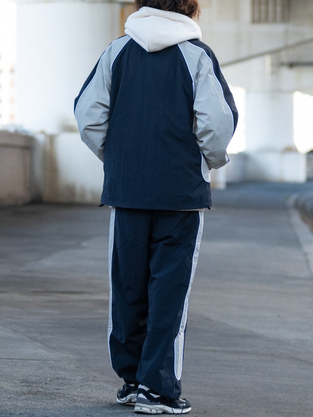 ブラック系のスニーカー、ホワイト系のパーカー、グレー系のその他パンツを着用したメンズの冬コーディネートの3枚目の写真