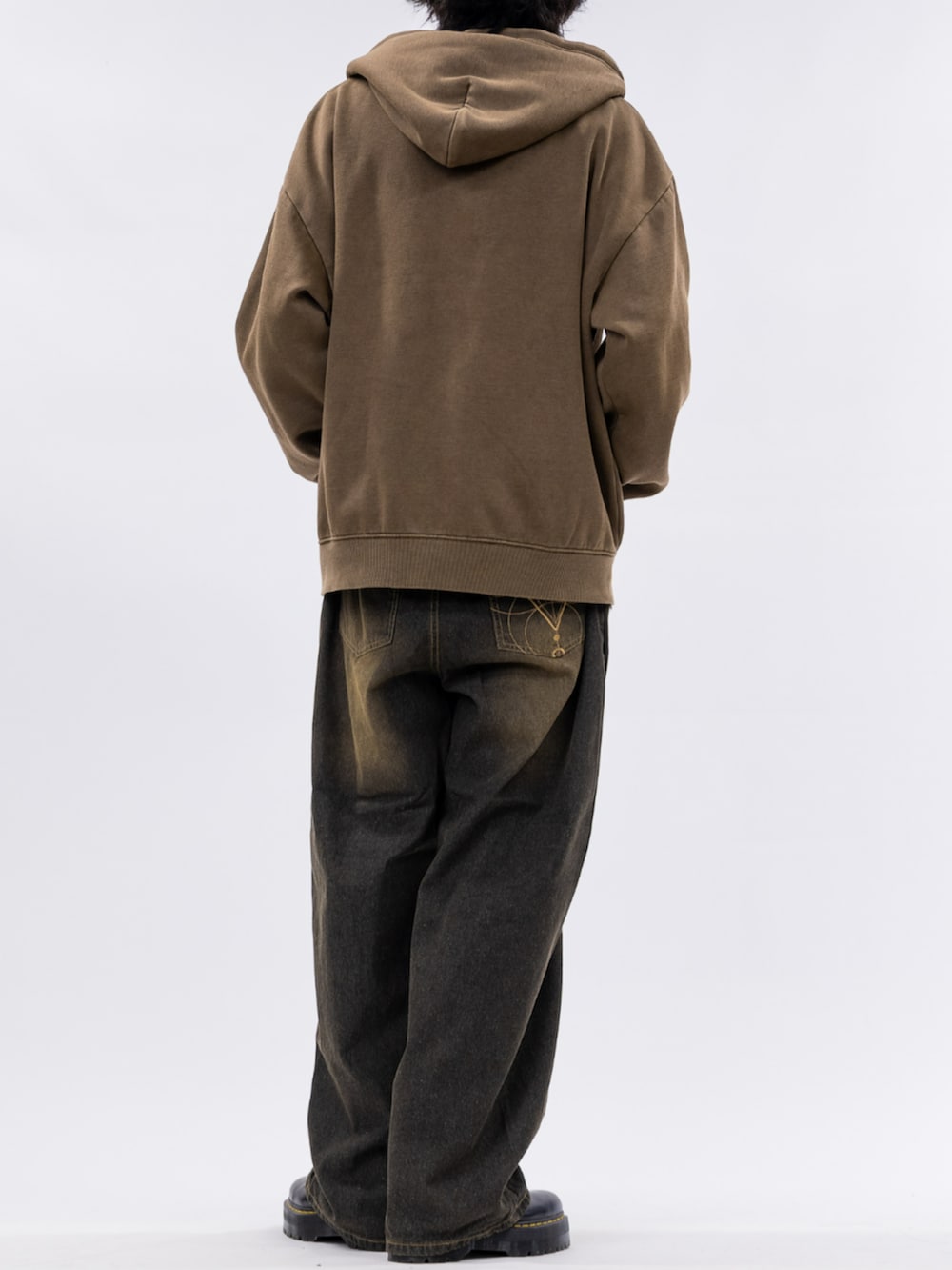 ブラウン系のパーカー、ブラック系のデニムパンツを着用したメンズの秋コーディネートの3枚目の写真