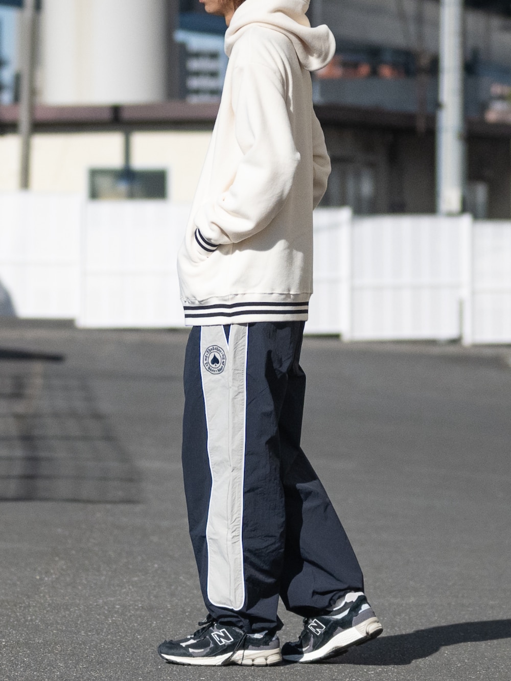 ブラック系のスニーカー、ブルー系のその他パンツ、ホワイト系のパーカーを着用したメンズの冬コーディネートの2枚目の写真