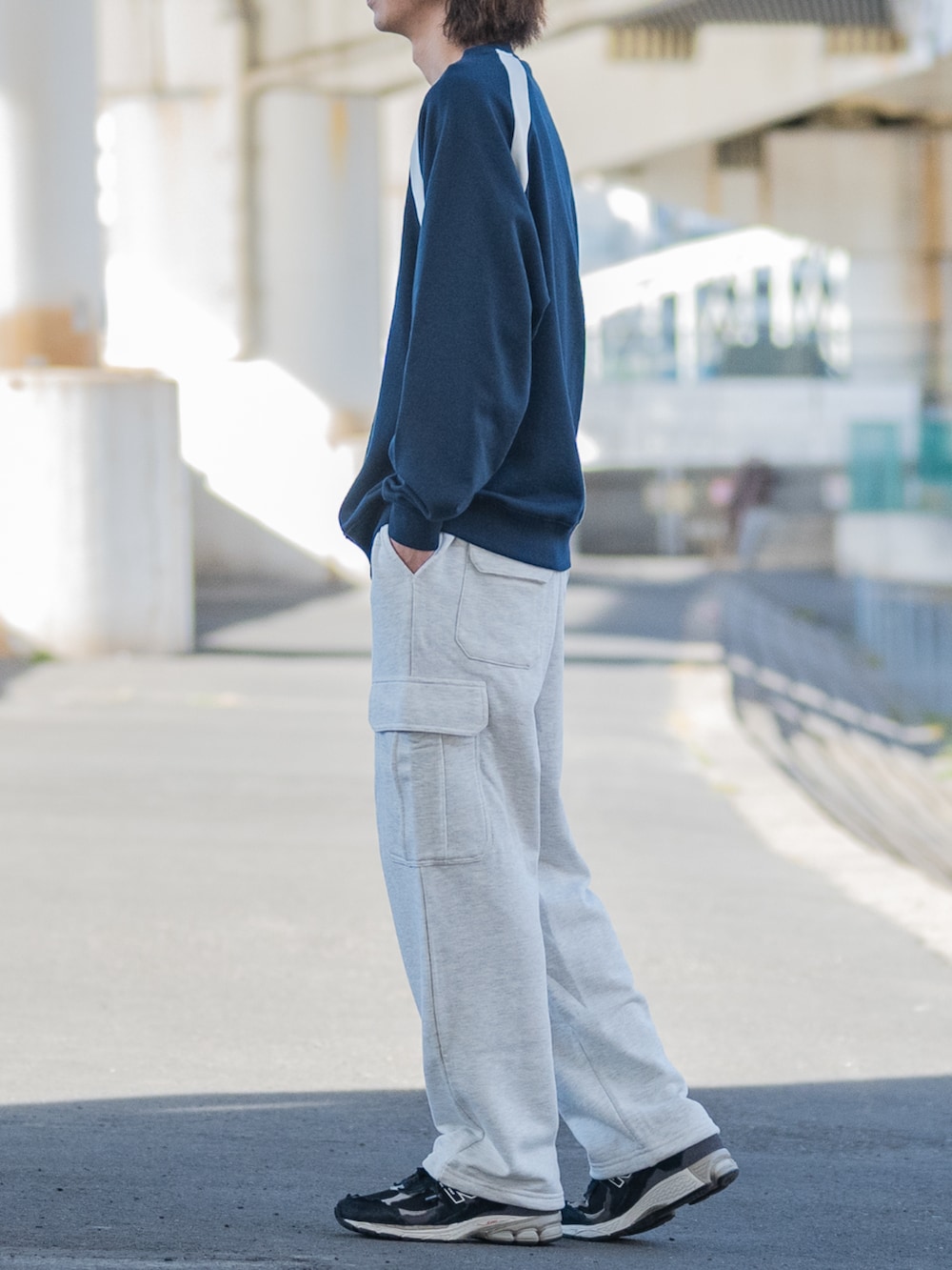 ブラック系のスニーカー、ブラック系のカーゴパンツ、ブルー系のスウェットを着用したメンズの冬コーディネートの2枚目の写真