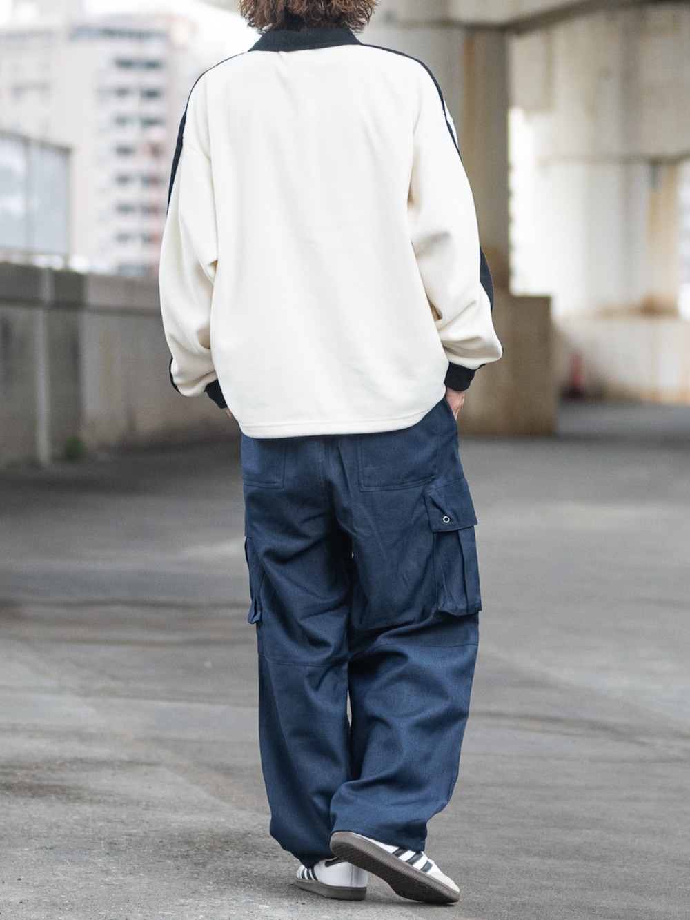 ホワイト系のスニーカー、ブラック系のカーゴパンツ、ホワイト系のスウェットを着用したメンズの冬コーディネートの3枚目の写真