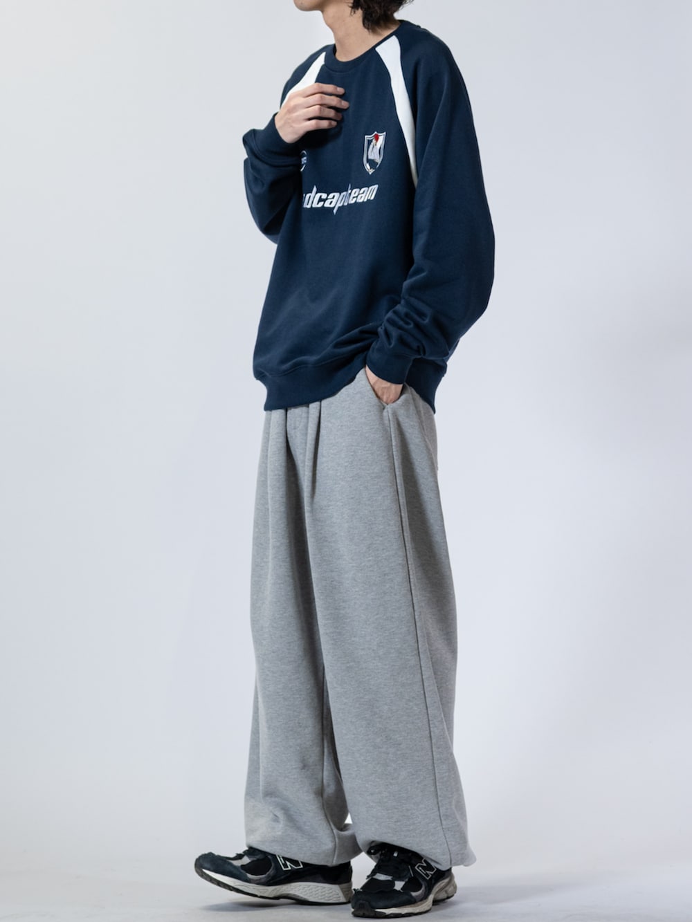 ブラック系のスニーカー、グレー系のスウェットパンツ、ブルー系のスウェットを着用したメンズの春コーディネートの2枚目の写真