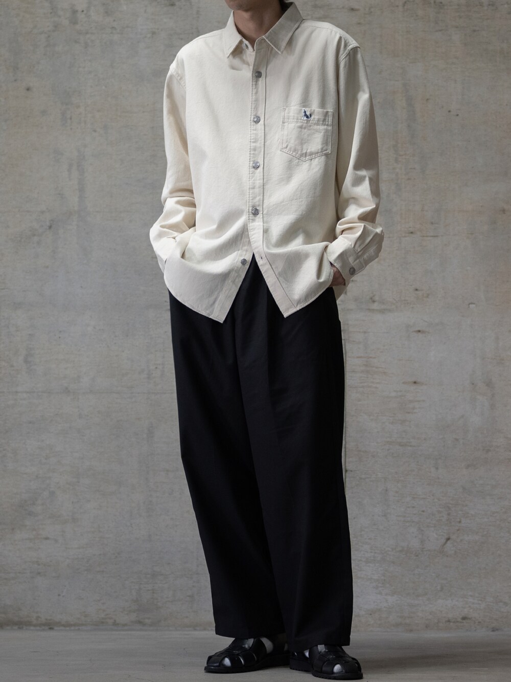 ブラック系のスラックス、ブラック系のサンダル、ホワイト系のシャツ/ブラウスを着用したメンズの夏コーディネートの2枚目の写真