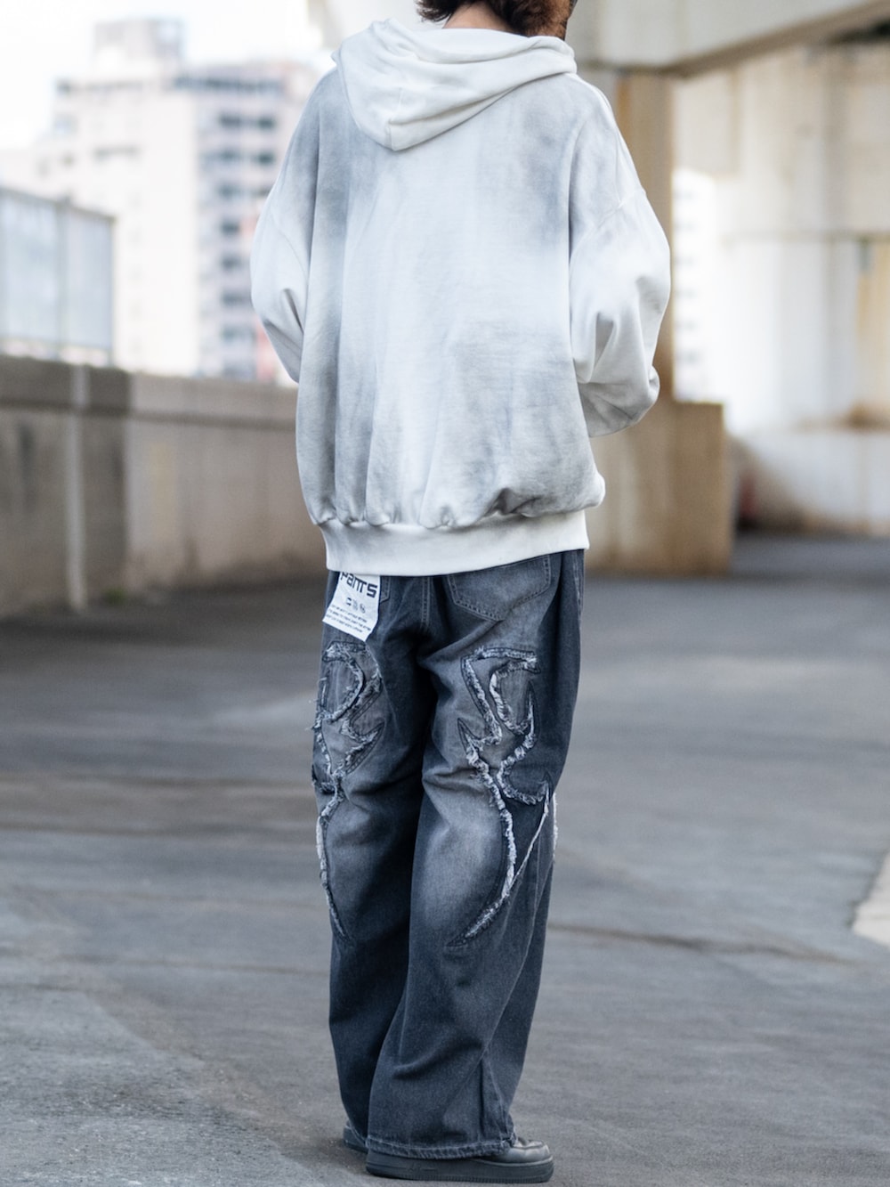 ホワイト系のパーカー、ブラック系のデニムパンツを着用したメンズの秋コーディネートの3枚目の写真