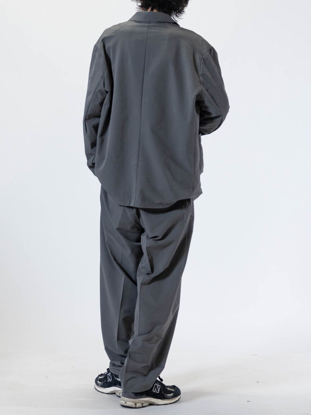 ホワイト系のTシャツ/カットソー、ブラック系のスニーカー、グレー系のチノパンツを着用したメンズの夏コーディネートの3枚目の写真