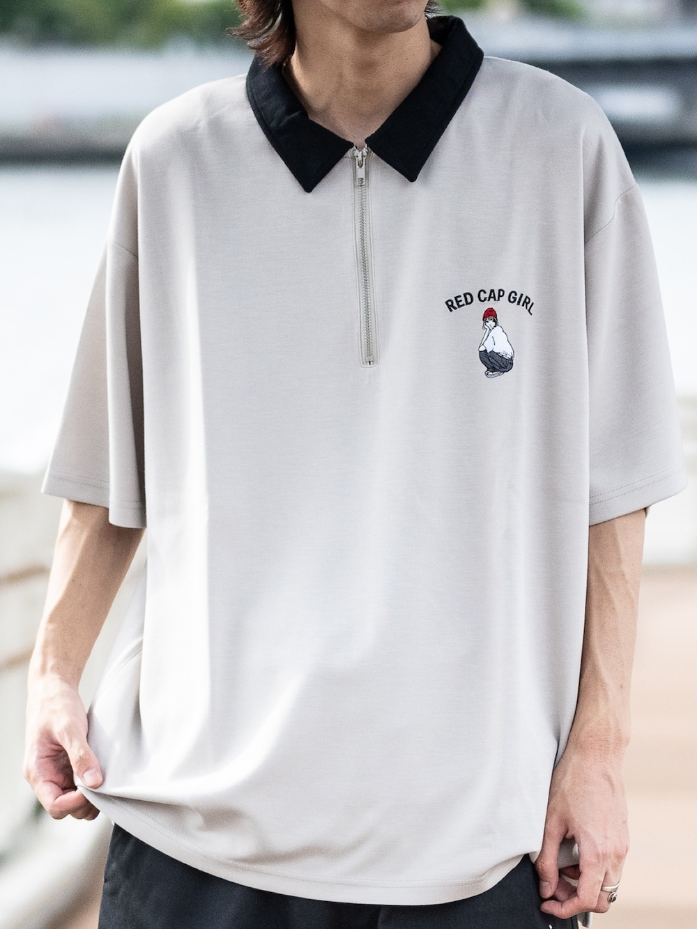 ベージュ系のポロシャツ、ブラック系のチノパンツ、ブラック系のスニーカーを着用したメンズの夏コーディネートの2枚目の写真