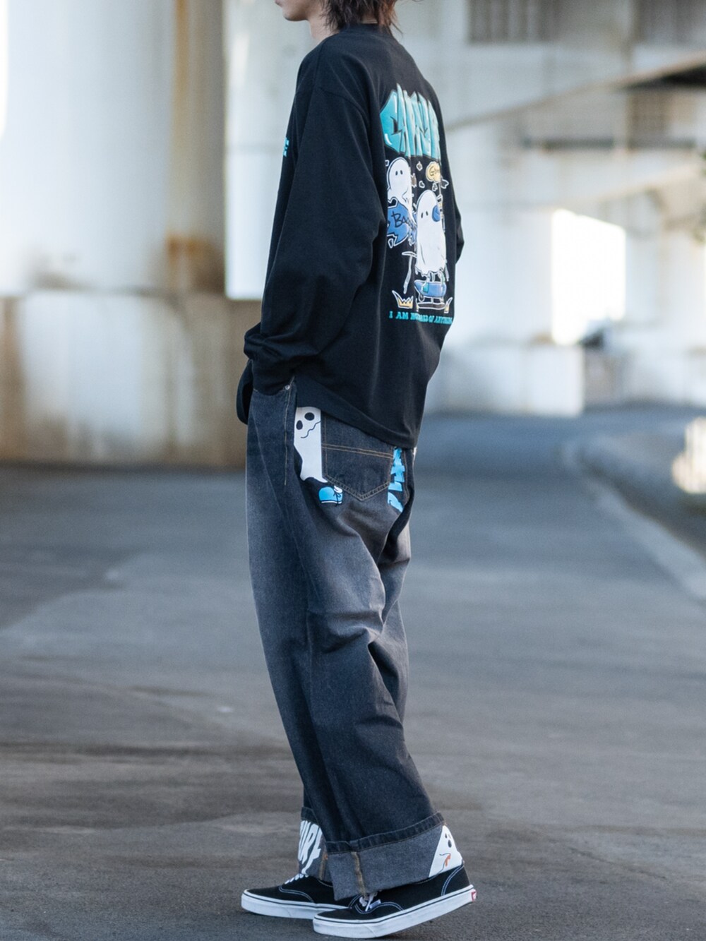ブラック系のスニーカー、ブルー系のデニムパンツ、ブラック系のTシャツ/カットソーを着用したメンズの春コーディネートの2枚目の写真