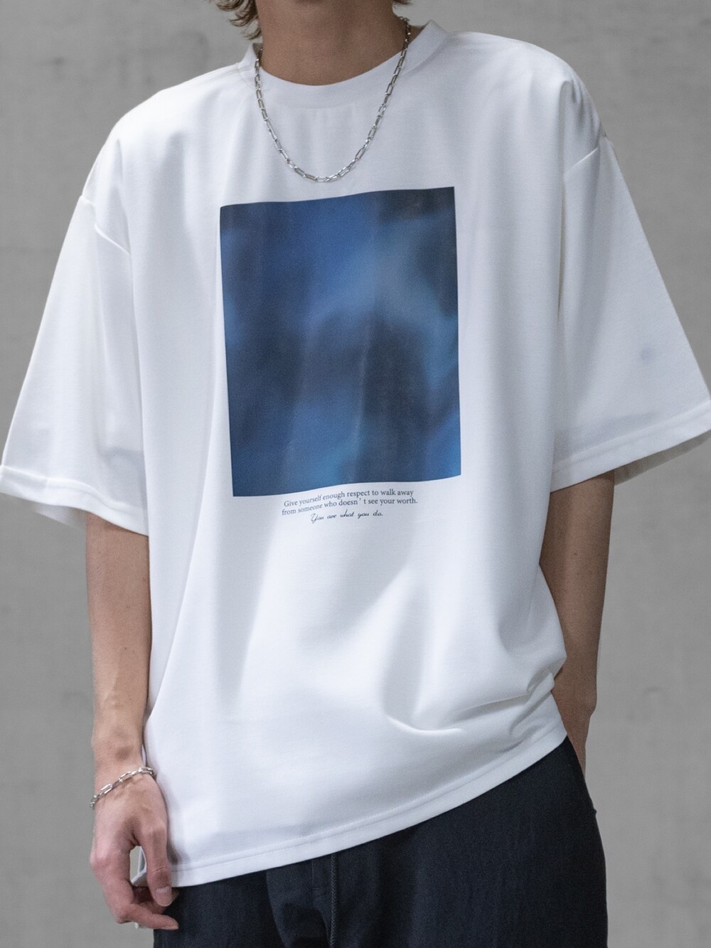 ブラック系のカーゴパンツ、ホワイト系のTシャツ/カットソー、ブラック系のドレスシューズを着用したメンズの春コーディネートの2枚目の写真