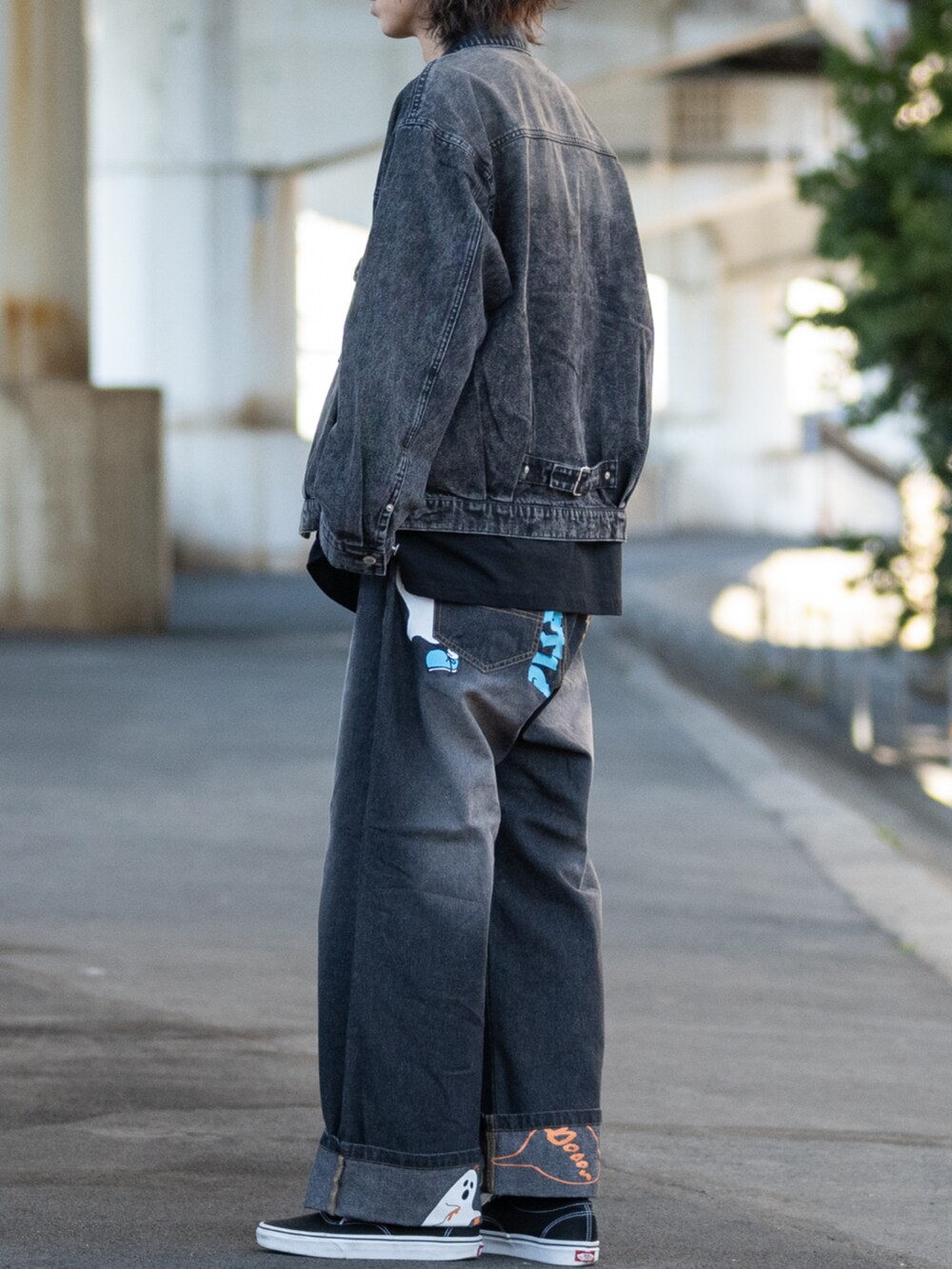 ブラック系のスニーカー、ブルー系のデニムパンツ、ブラック系のTシャツ/カットソーを着用したメンズの春コーディネートの2枚目の写真