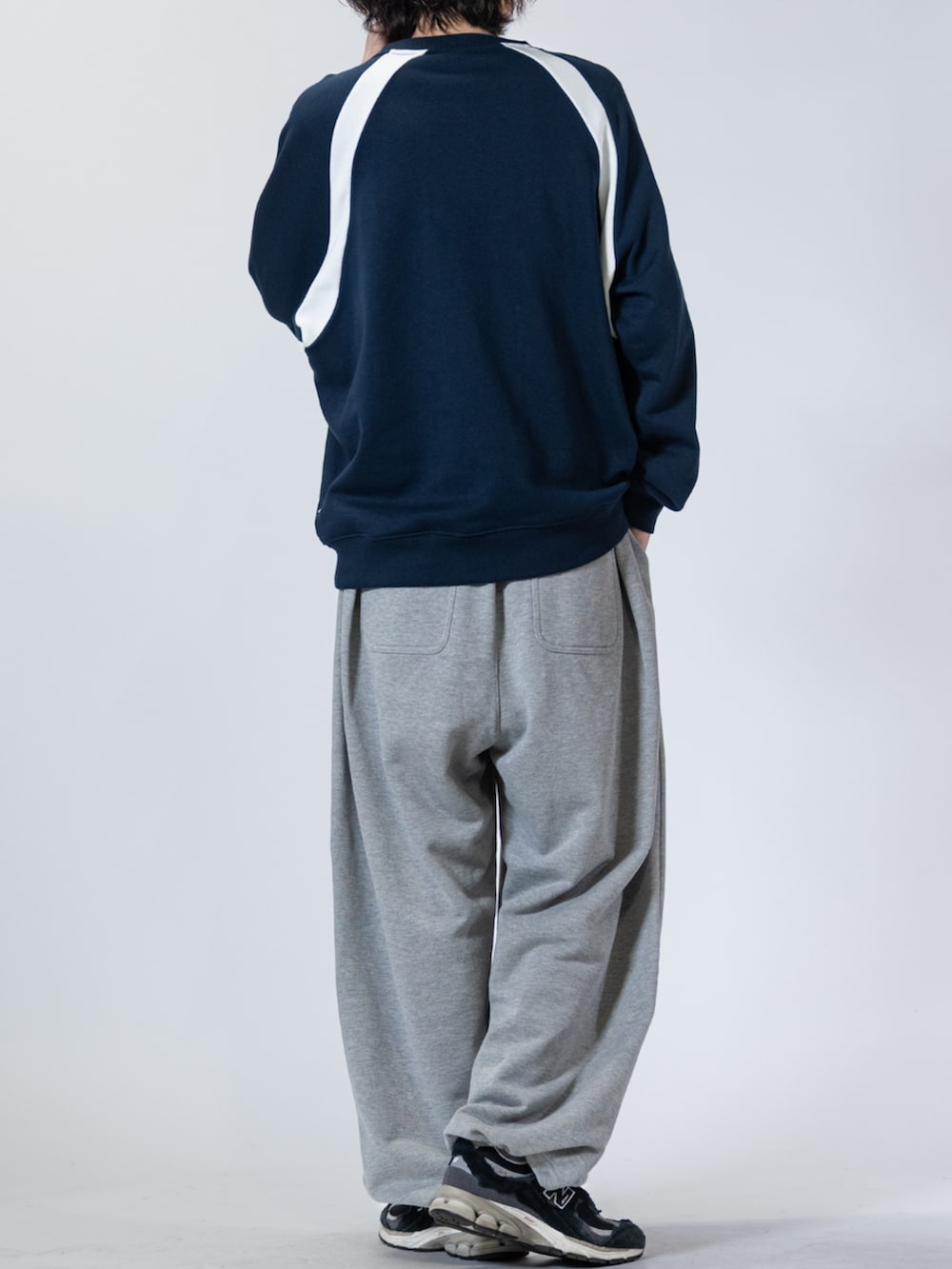 ブラック系のスニーカー、グレー系のスウェットパンツ、ブルー系のスウェットを着用したメンズの春コーディネートの3枚目の写真