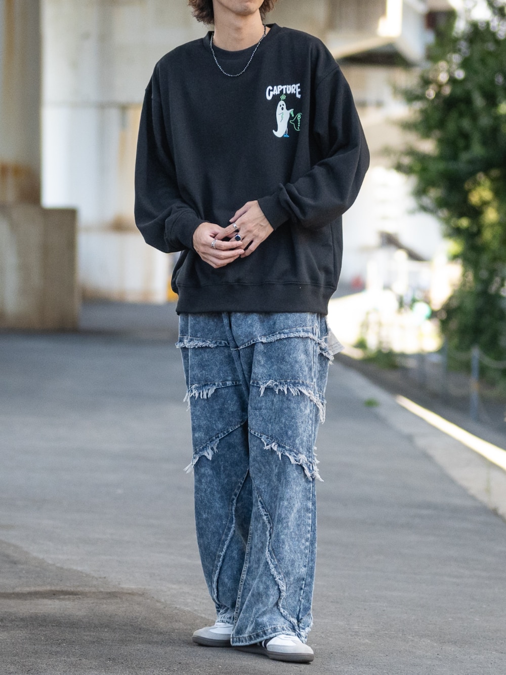 ホワイト系のスニーカー、ブルー系のデニムパンツ、ブラック系のスウェットを着用したメンズの秋コーディネートの3枚目の写真