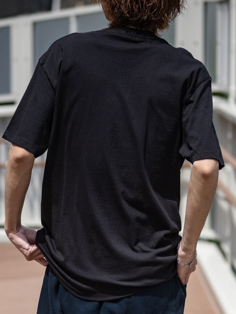 ブラック系のTシャツ/カットソー、ブラック系のスニーカー、ブルー系のスウェットパンツを着用したメンズの春コーディネートの4枚目の写真