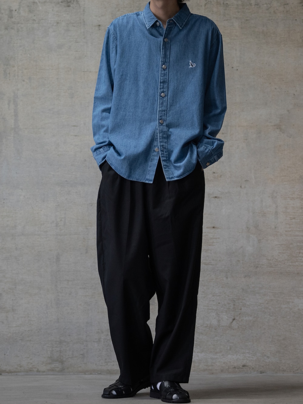 ブラック系のスラックス、ブラック系のサンダル、ブルー系のシャツ/ブラウスを着用したメンズの夏コーディネートの2枚目の写真