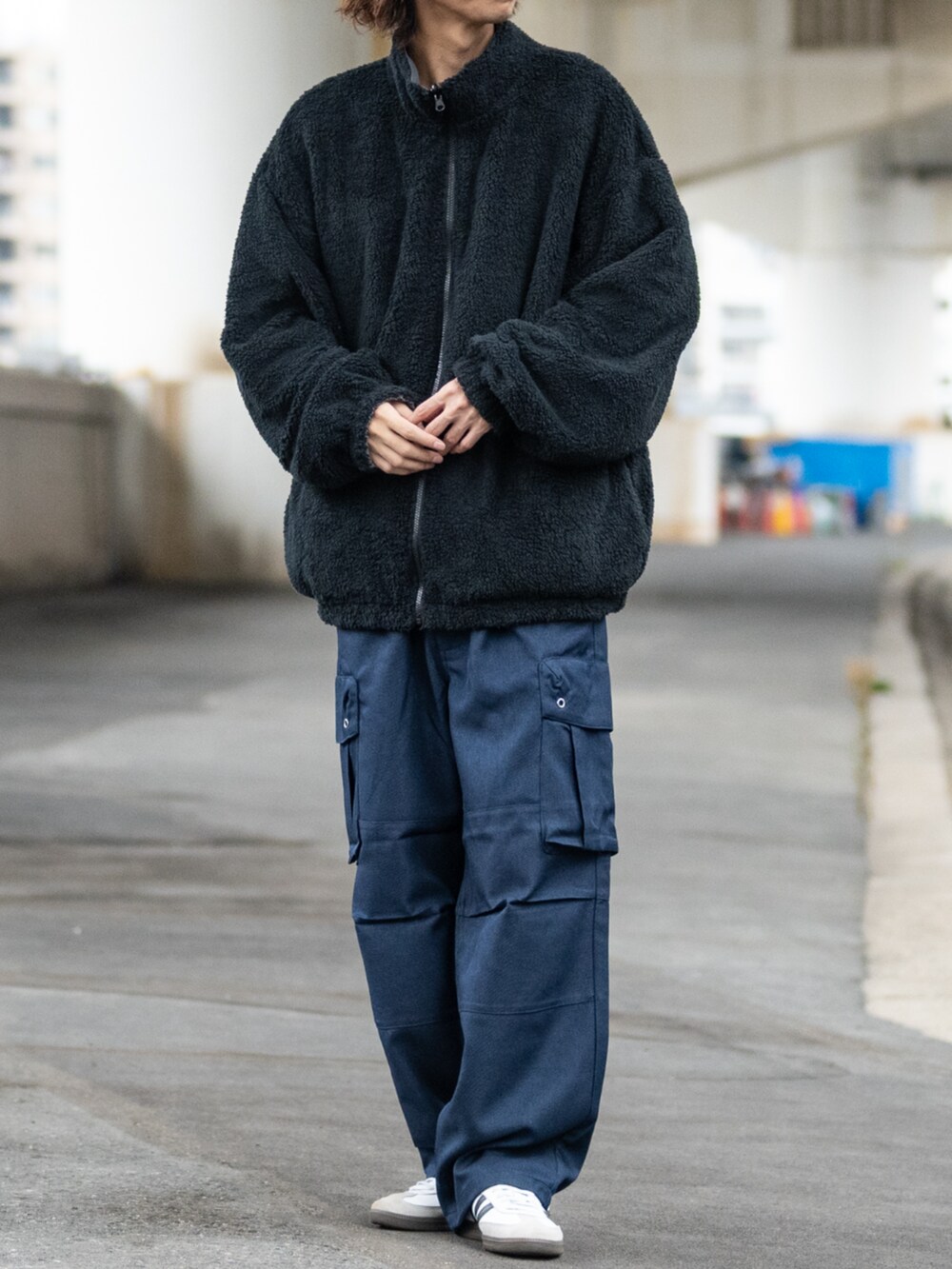 ホワイト系のスニーカー、ブラック系のカーゴパンツ、グレー系のナイロンジャケットを着用したメンズの冬コーディネートの3枚目の写真