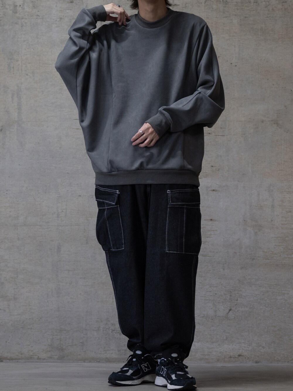 ブルー系のデニムパンツ、ブラック系のスニーカー、グレー系のスウェットを着用したメンズの秋コーディネートの2枚目の写真