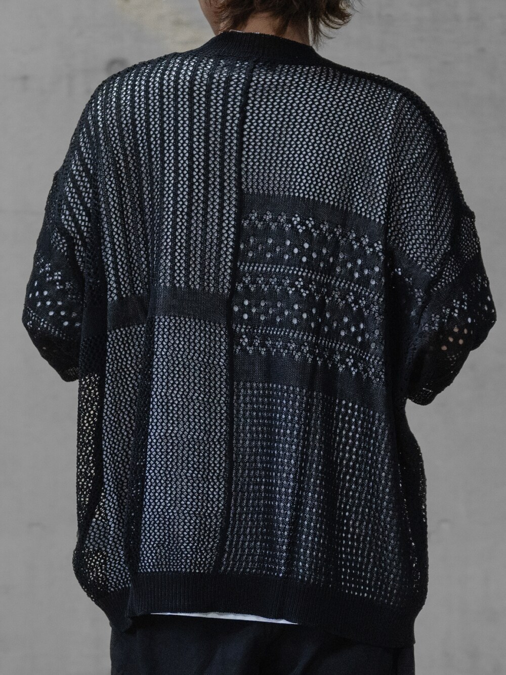 グレー系のスラックス、ブラック系のドレスシューズ、ブラック系のニット/セーターを着用したメンズの春コーディネートの4枚目の写真