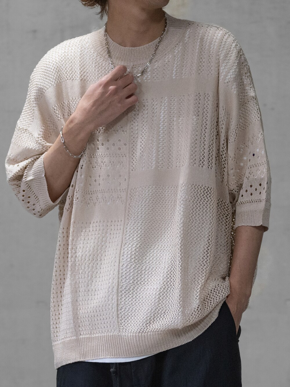 ブラック系のニット/セーター、ブラック系のデニムパンツ、ブラック系のドレスシューズを着用したメンズの春コーディネートの2枚目の写真