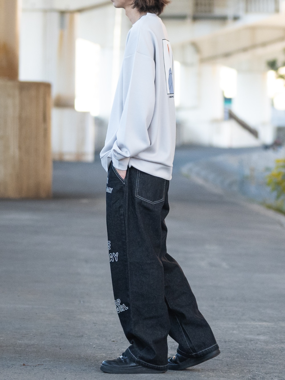 グレー系のスウェット、ブラック系のデニムパンツを着用したメンズの冬コーディネートの2枚目の写真