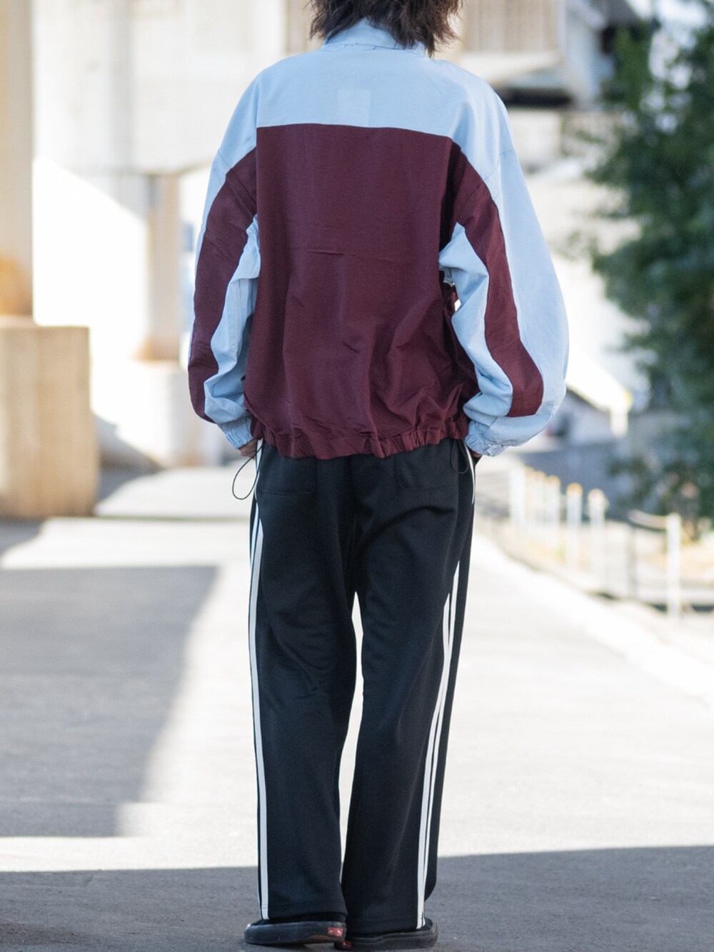 ブラック系のスニーカー、レッド系のナイロンジャケット、ブラック系のその他パンツを着用したメンズの春コーディネートの3枚目の写真