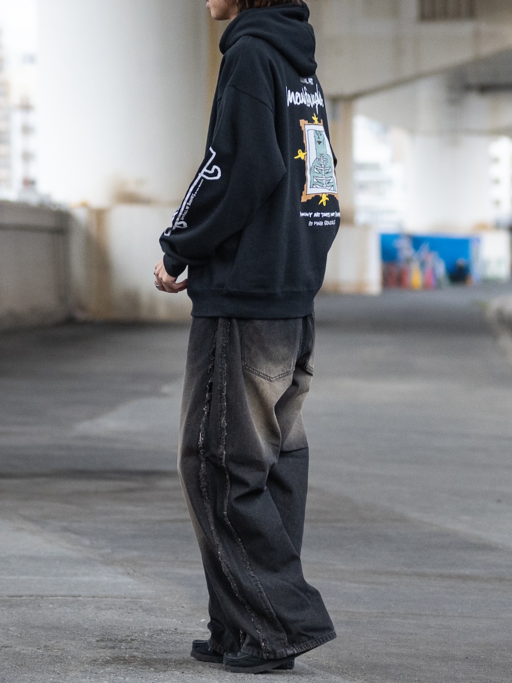 ブラウン系のデニムパンツ、ブラック系のパーカーを着用したメンズの冬コーディネートの2枚目の写真