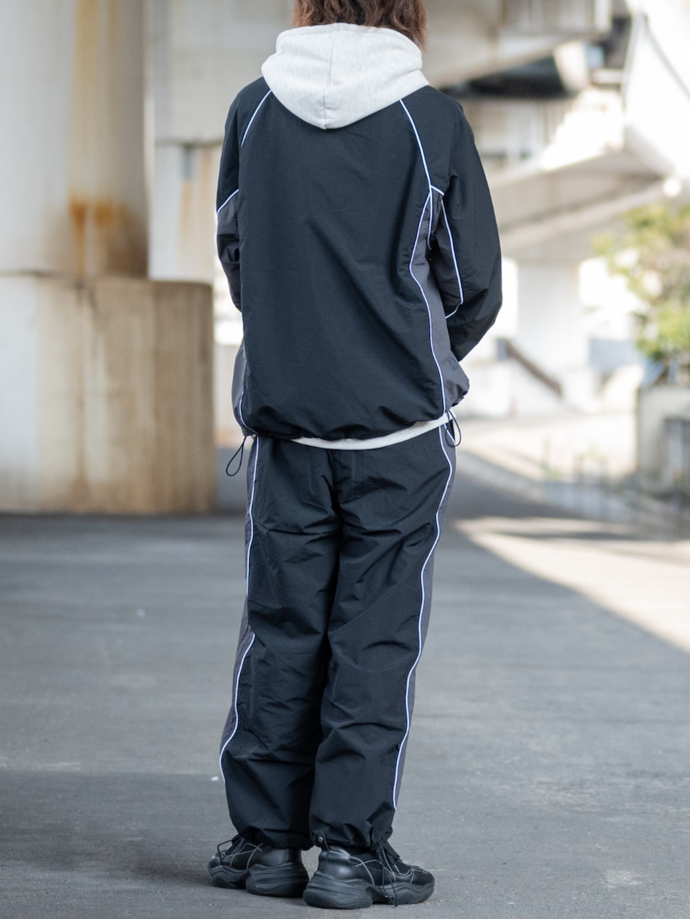 ブラック系のその他パンツ、ブラック系のジャージ、ホワイト系のパーカーを着用したメンズの冬コーディネートの3枚目の写真
