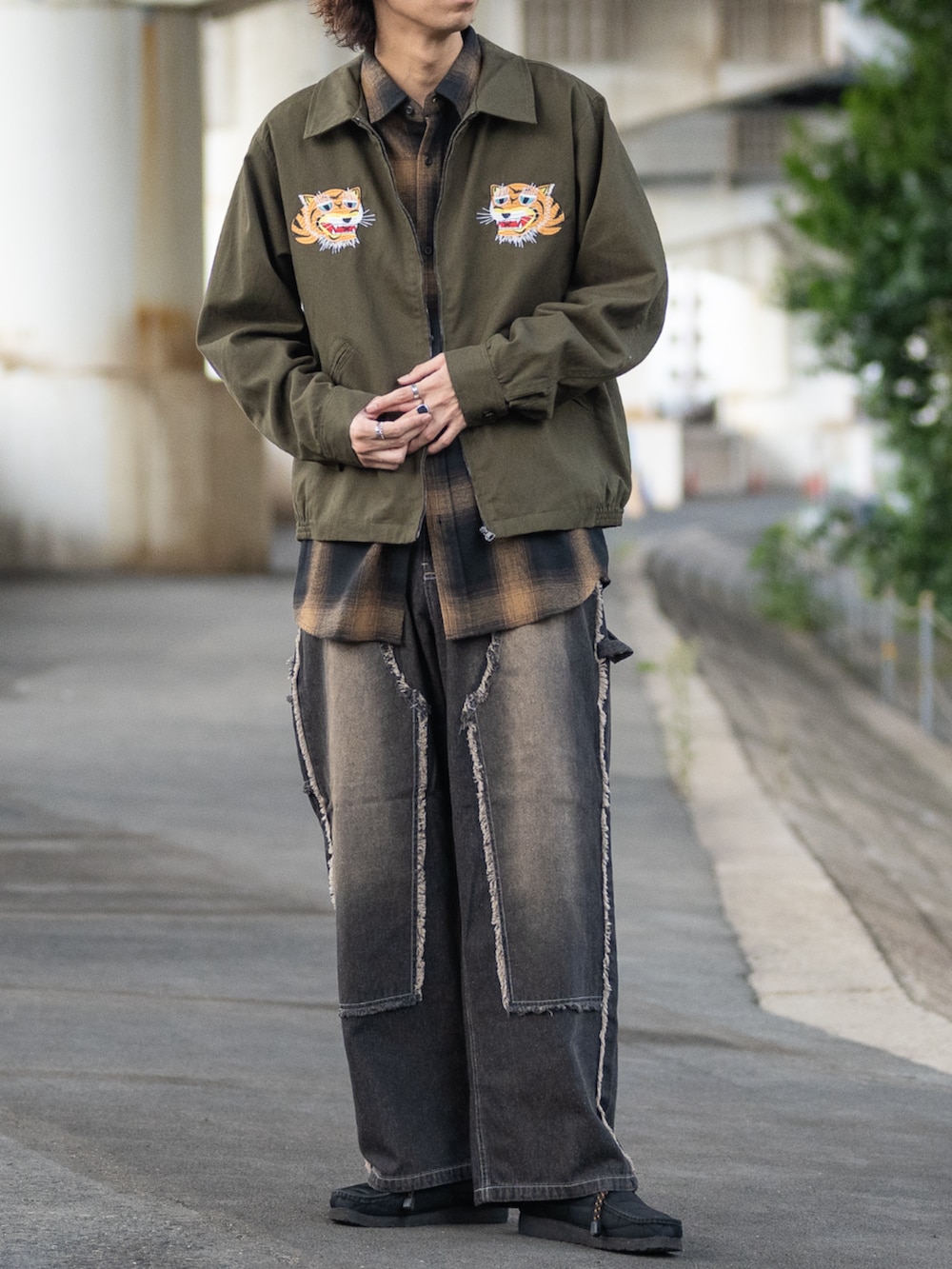 ブラック系のシャツ/ブラウス、グリーン系のミリタリージャケット、ブラック系のデニムパンツを着用したメンズの秋コーディネートの3枚目の写真