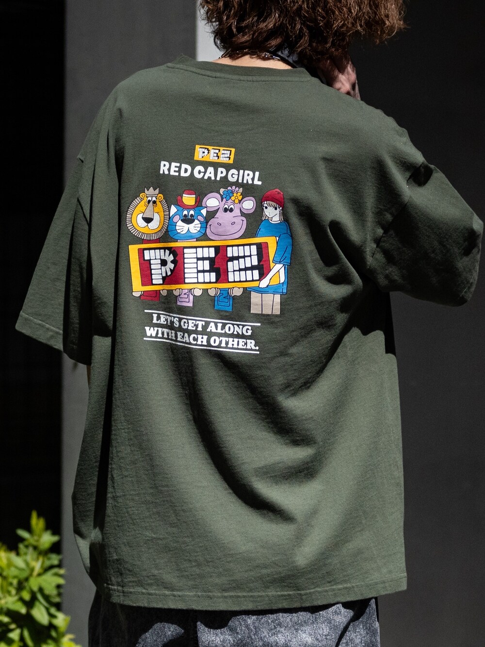 ブラック系のカーゴパンツ、グリーン系のTシャツ/カットソー、ブラック系のスニーカーを着用したメンズの春コーディネートの3枚目の写真