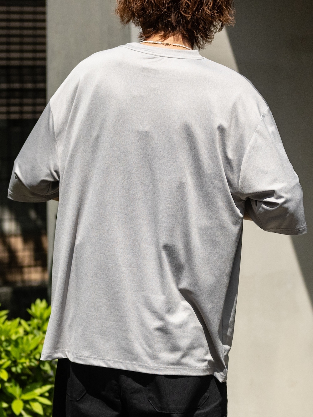 ベージュ系のTシャツ/カットソー、ブラック系のデニムパンツを着用したメンズの春コーディネートの4枚目の写真