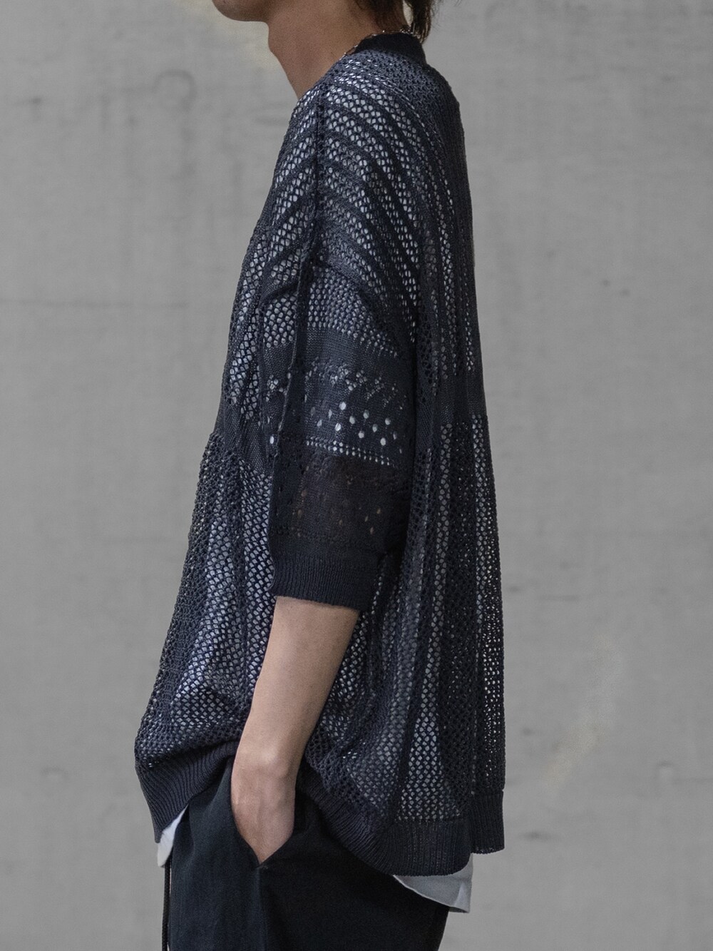 ブラック系のデニムパンツ、ブラック系のドレスシューズ、グレー系のニット/セーターを着用したメンズの春コーディネートの3枚目の写真