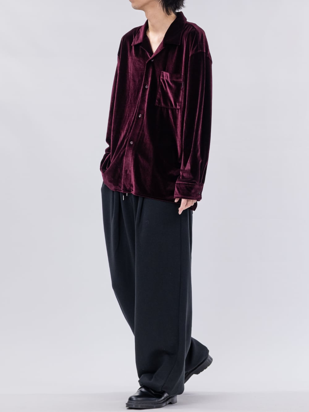 ブラック系のドレスシューズ、グレー系のスラックス、パープル系のシャツ/ブラウスを着用したメンズの冬コーディネートの2枚目の写真