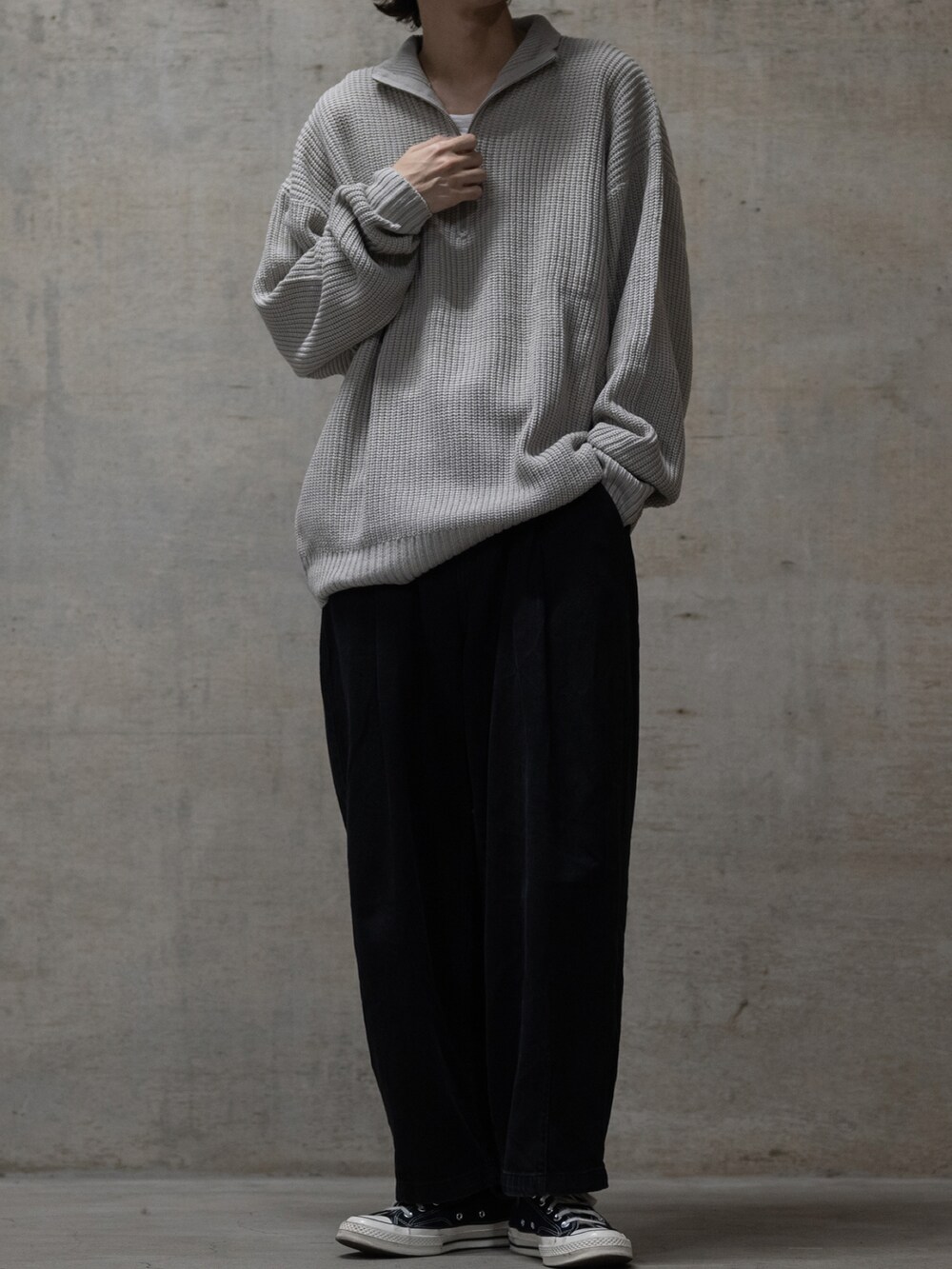 ブラック系のスニーカー、ブラック系のデニムパンツ、ベージュ系のニット/セーターを着用したメンズの秋コーディネートの2枚目の写真