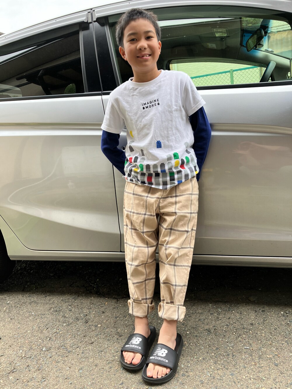 ブラック系のサンダル、ベージュ系のその他パンツ、ホワイト系のTシャツ/カットソーを着用したキッズの春コーディネートの2枚目の写真