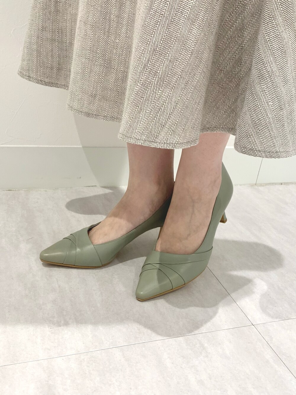 グリーン系のパンプスを着用したレディースの春コーディネートの2枚目の写真