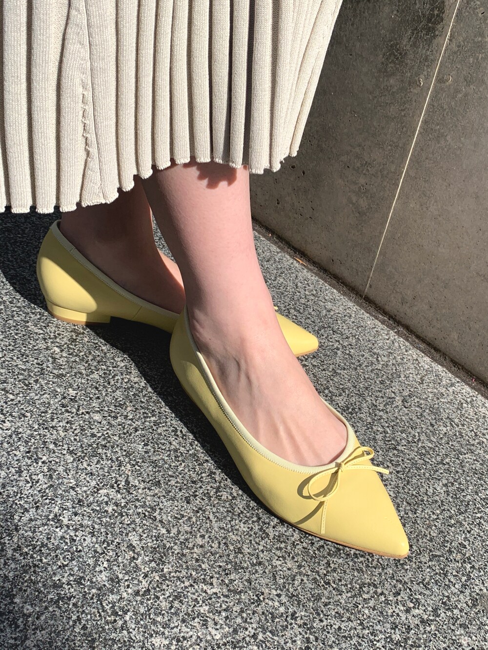 イエロー系のバレエシューズを着用したレディースの春コーディネートの2枚目の写真