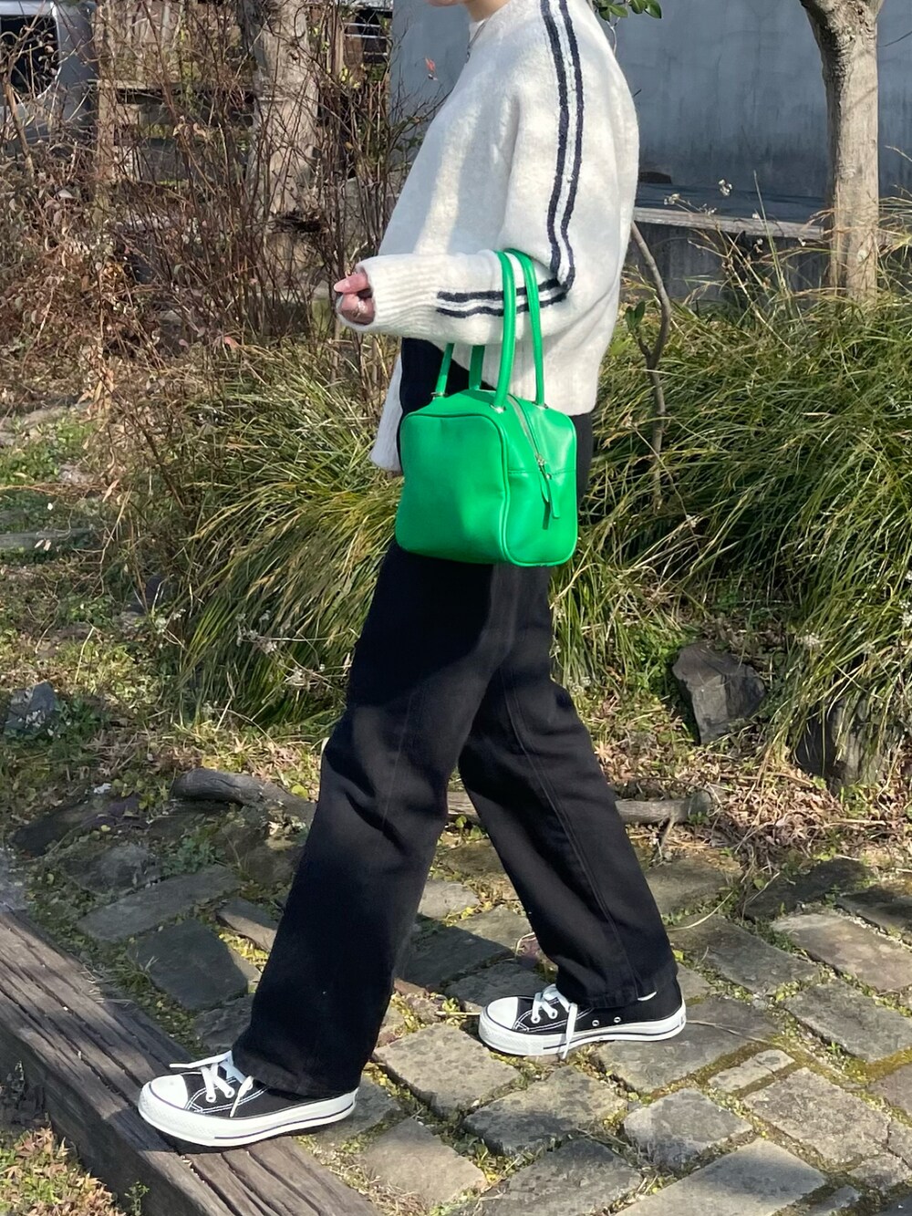 ホワイト系のニット/セーター、ブラック系のデニムパンツ、ブラック系のスニーカーを着用したレディースの冬コーディネートの2枚目の写真