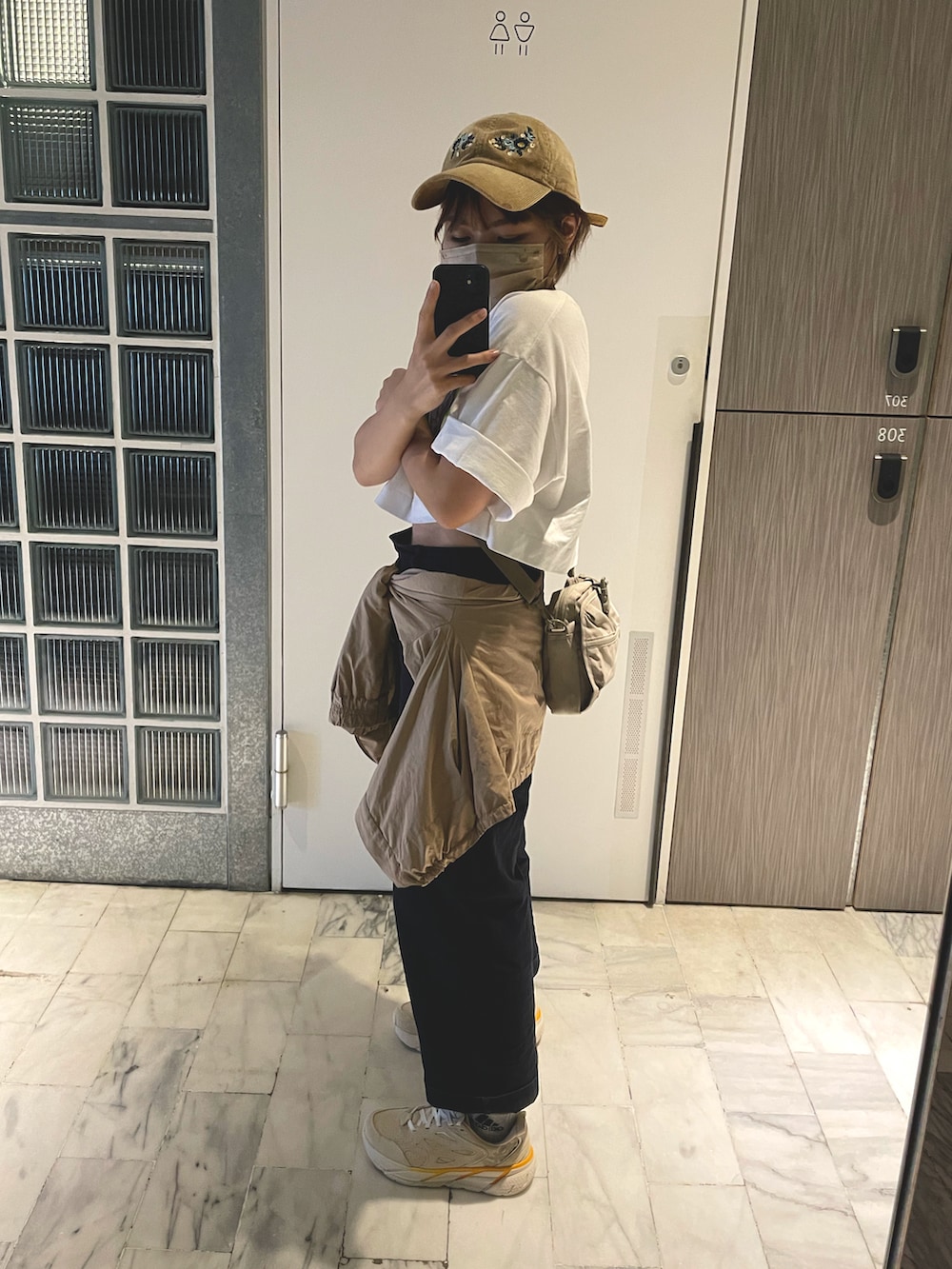 ベージュ系のスニーカー、ブルー系のチノパンツ、ベージュ系のブルゾンを着用したレディースの春コーディネートの2枚目の写真