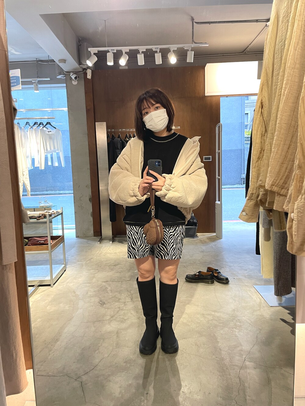 ベージュ系のノーカラージャケット、ブラック系のスウェット、ブラック系のカーゴパンツを着用したレディースの冬コーディネートの2枚目の写真