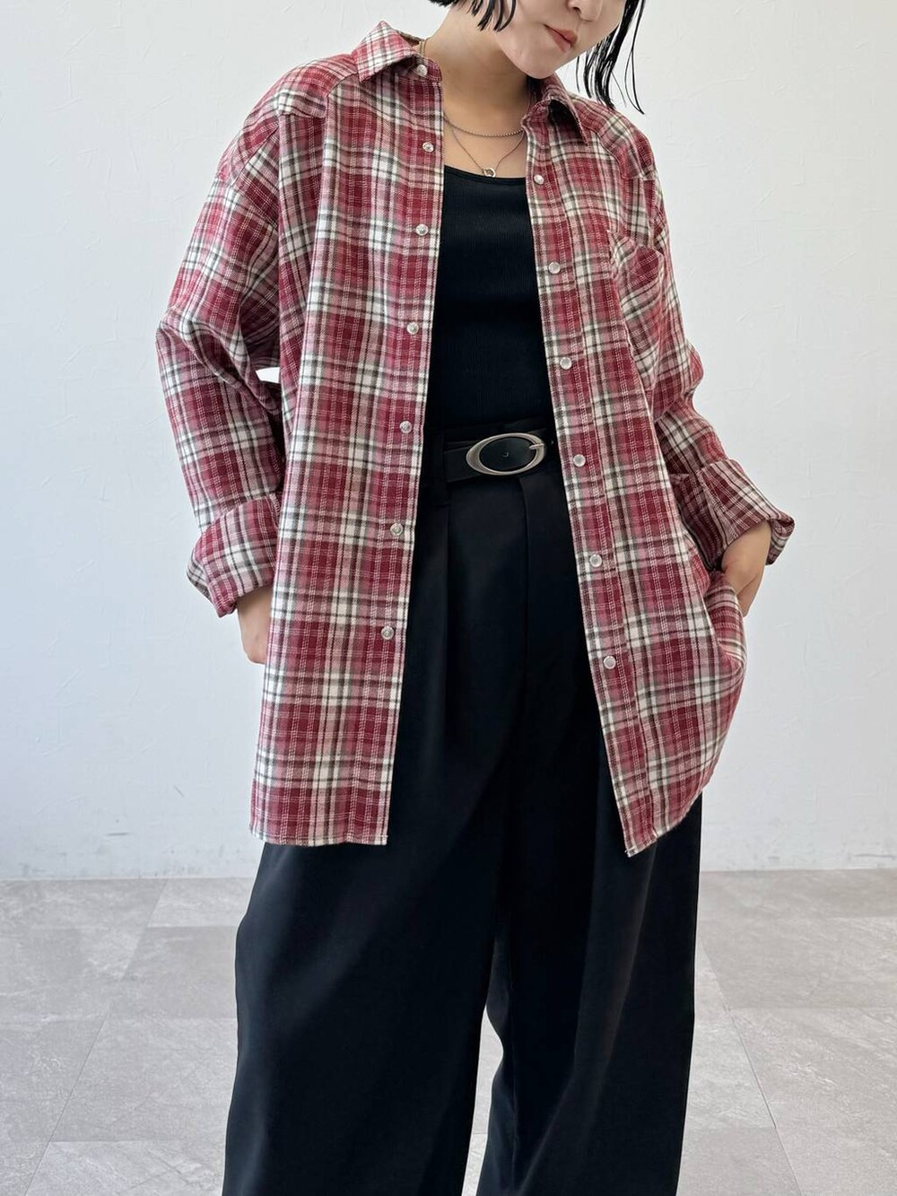 レッド系のシャツ/ブラウス、ブラック系のスラックスを着用したレディースの夏コーディネートの2枚目の写真